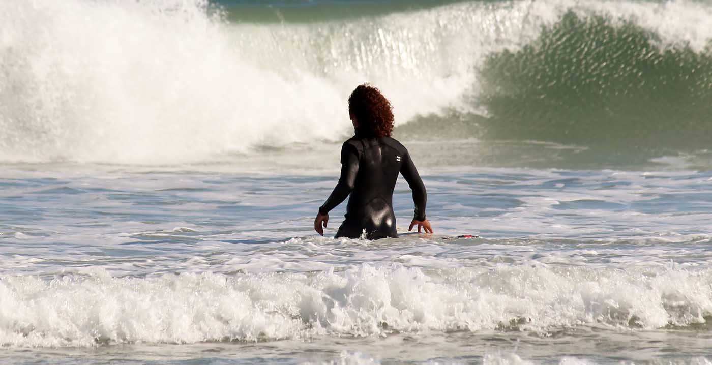 Surfer wading out in the surf